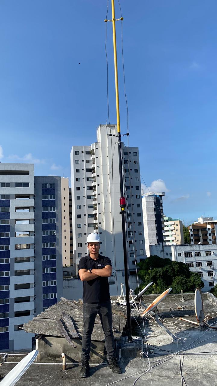 Engenheiro da Soluki em cobertura ao lado de sistema de SPDA instalado